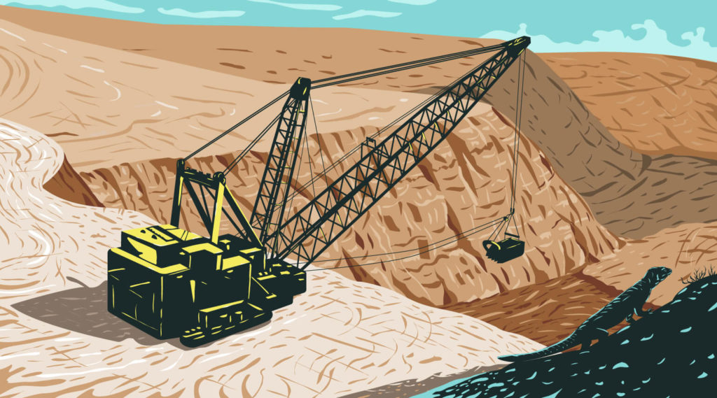 An excavating machine sits next to an open pit mine